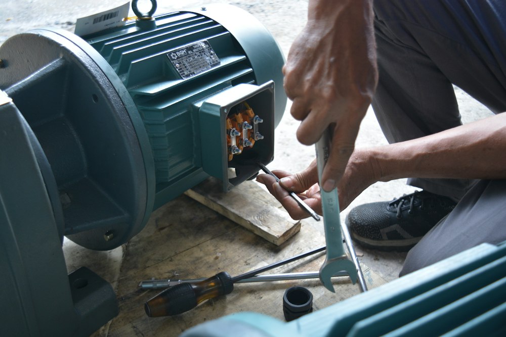 Técnico revisando un motor eléctrico con llave en su comuna